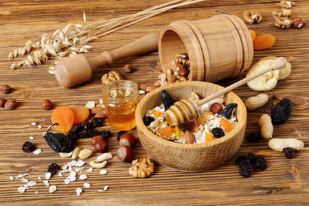 Granola with oatmeal, nuts, dried fruit and honey  on the tableの写真素材