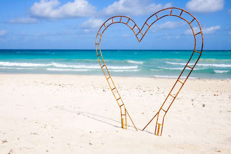 The design of metal in the form of a heart on the sea beach, the concept of tourism and recreationの写真素材