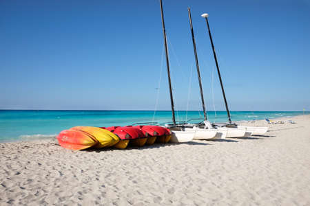 Canoes and catamarans on a sandy beach against the blue sea, the concept of outdoor activitiesの写真素材