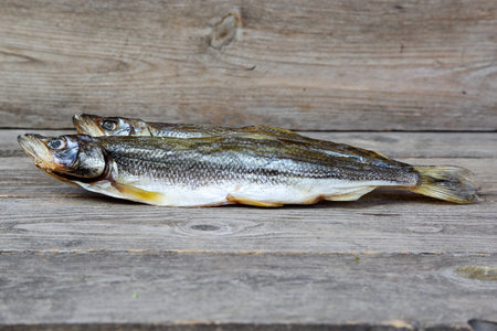 Sun-dried sea fish - smelt on a gray wooden table, close-up