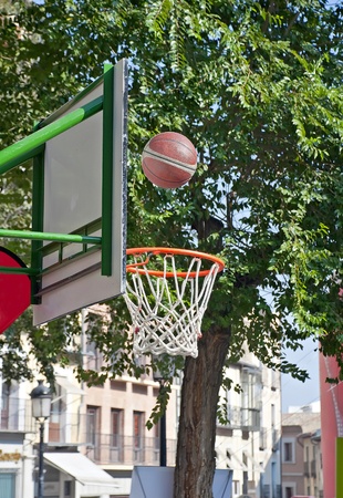 Basketball going into the basket placed in the streetの写真素材