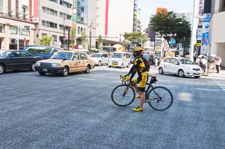 TOKYO, JAPAN-JULY 6: cyclist and traffic on one of the main streets of Ginza on July 6, 2011 in Tokyo, Japan  Ginza is famous for the concentration of department stores, boutiques and restaurantsのeditorial素材