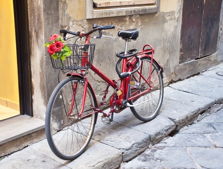 Retro bike in red with a bouquet of flowers in the basketの写真素材