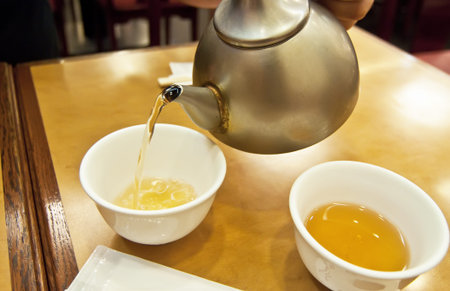 Serving tea in two cups in a Japanese restaurant.