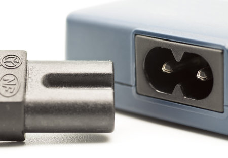 Battery charger and power cable close-up on white background 