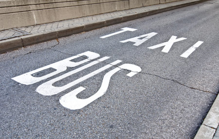 Bus and taxi sign painted on the pavement indicating the lane