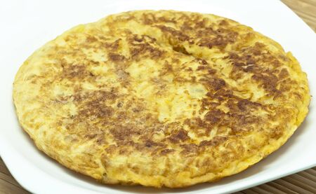 Spanish potato omelet on a white dish の写真素材