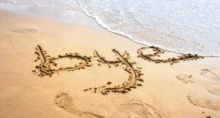 Bye written in the sand on the beach の写真素材