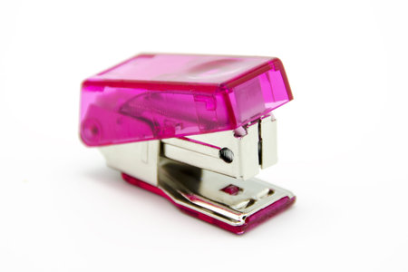 Pink stapler on white background