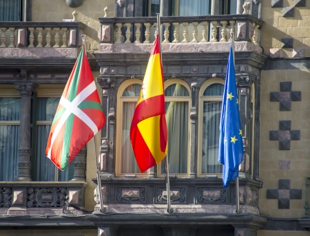 Flags of Euskadi, Spain and European Union waving in the facade of a buildingの写真素材