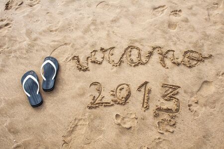 2013 written in the sand on the beach in summer with sandalsの写真素材