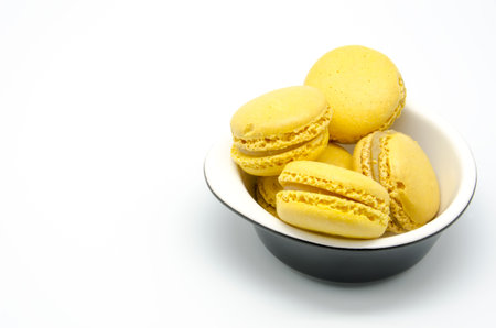 Yellow macaroons on white background