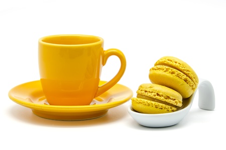 Yellow macaroons on a spoon over a cupの写真素材