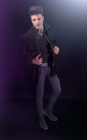 Fashion young man in jeans and jacket on black backgroundの写真素材