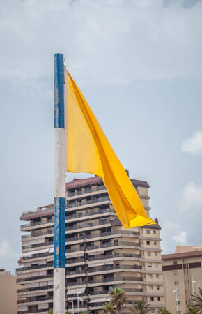 Yellow flag on the beach in Gandia, Spainの写真素材