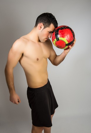 Muscular young man with balloon on gray backgroundの写真素材