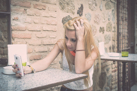 Beautiful young woman in the sreet with mobileの写真素材