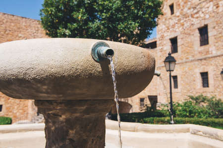 Photographed closeup of water falling from a stone fountainの写真素材
