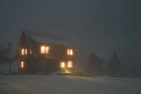 house with light windows in the darkの写真素材