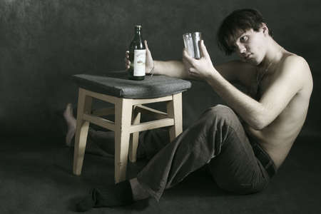 tipsy man with bottle  and glassの写真素材