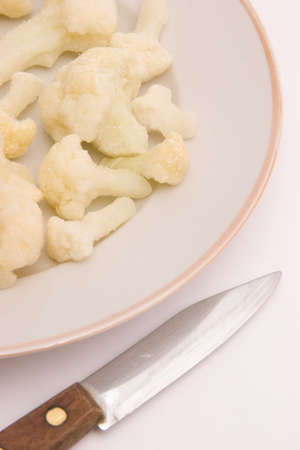 knife near plate with frozen cauliflowerの写真素材