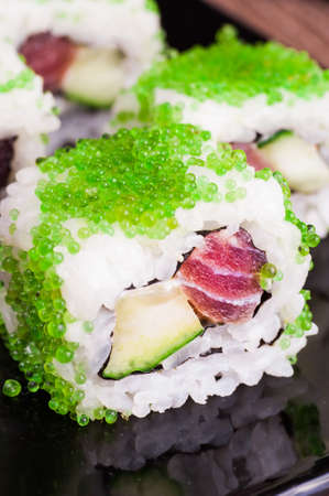 sushi roll set in green caviar on wooden backgroundの写真素材