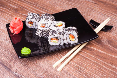 salmon and avocado sushi roll on wooden backgroundの写真素材