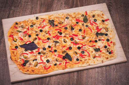 super big pizza to share on wooden plateの写真素材