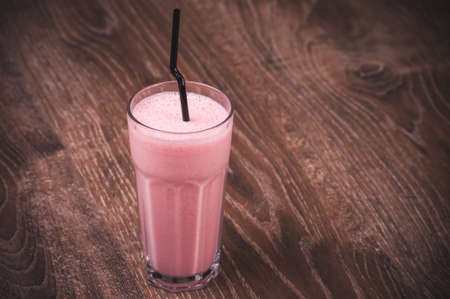 strawberry milkshake with straw in high glassの写真素材