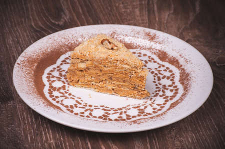 Nut cake slice with honey on white plateの写真素材