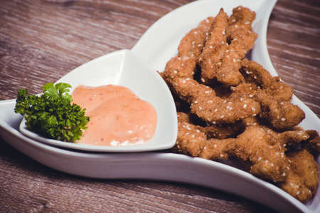 deep fried chiken breast strips on white plateの写真素材