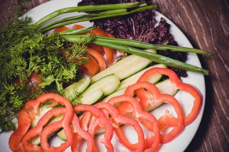 cut tomato, cucumber and bell pepper, on white plateの写真素材