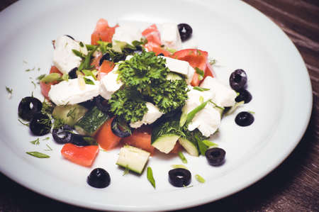 vegetarian greek salad served on white plateの写真素材