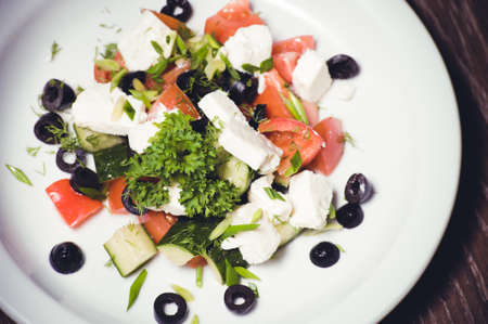 vegetarian greek salad served on white plateの写真素材