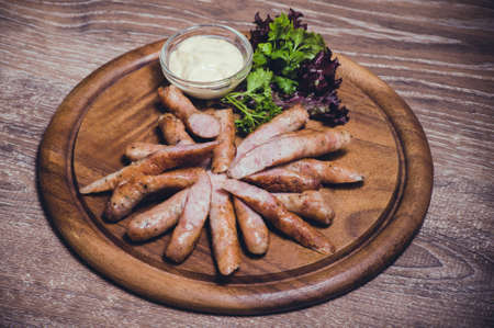 pork fried sausages with dip on wooden plateの写真素材
