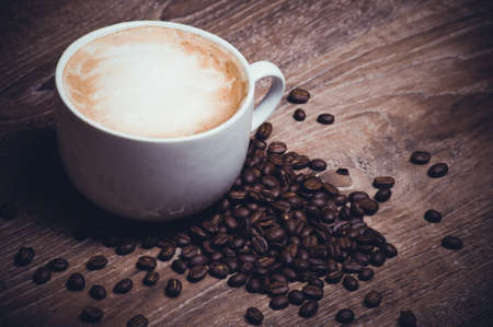 coffe with milk im mug with coffe beansの写真素材