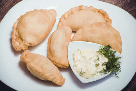 patties with dip and dill on white plateの写真素材