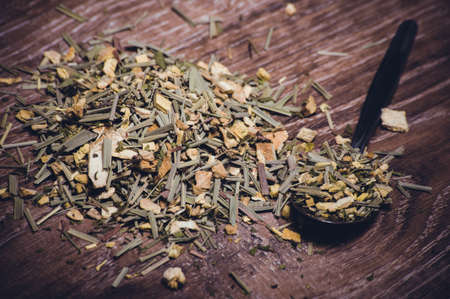 dried herbal tea on spoon on wooden backgroundの写真素材