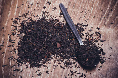 black tea dried leafs on spoon  on wooden backgroundの写真素材