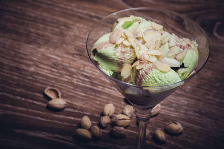 pistachio ice cream in martini glass with almond flakesの写真素材