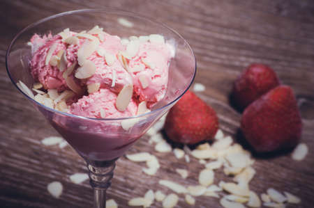 strawberry ice cream in glass with almond flakesの写真素材
