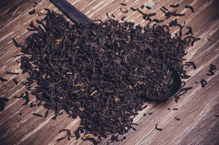 black tea dried leafs on spoon  on wooden backgroundの写真素材