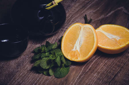 orange and mint tea served in cup and teapotの写真素材