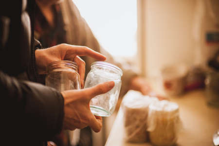 men hand hold empty glass jar no faceの写真素材