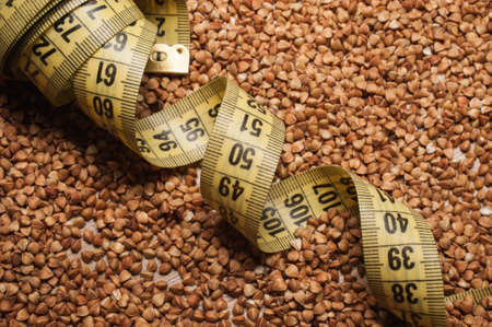 yellow centimeter tape on backwheat background textureの写真素材