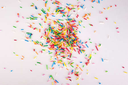 Mini sweet sprinkles  making a border isolated on white background  with sample textの写真素材