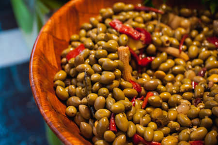 Green olives with pepper and baby corn  in wooden bucket sold on a marketの写真素材