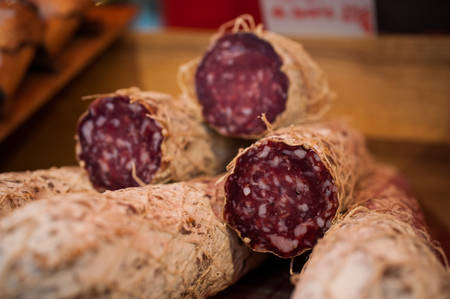 pile of salami cut in a half sold on marketの写真素材
