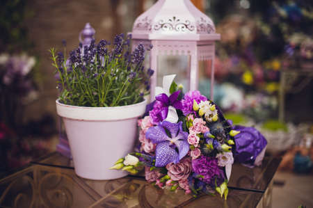purple bouquet composition of roses and orchid on decorated tableの写真素材