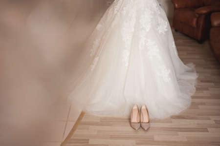 white bridal wedding dress and shoes on a chairの写真素材